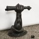 Wall lamp in iron shaped like an arm.