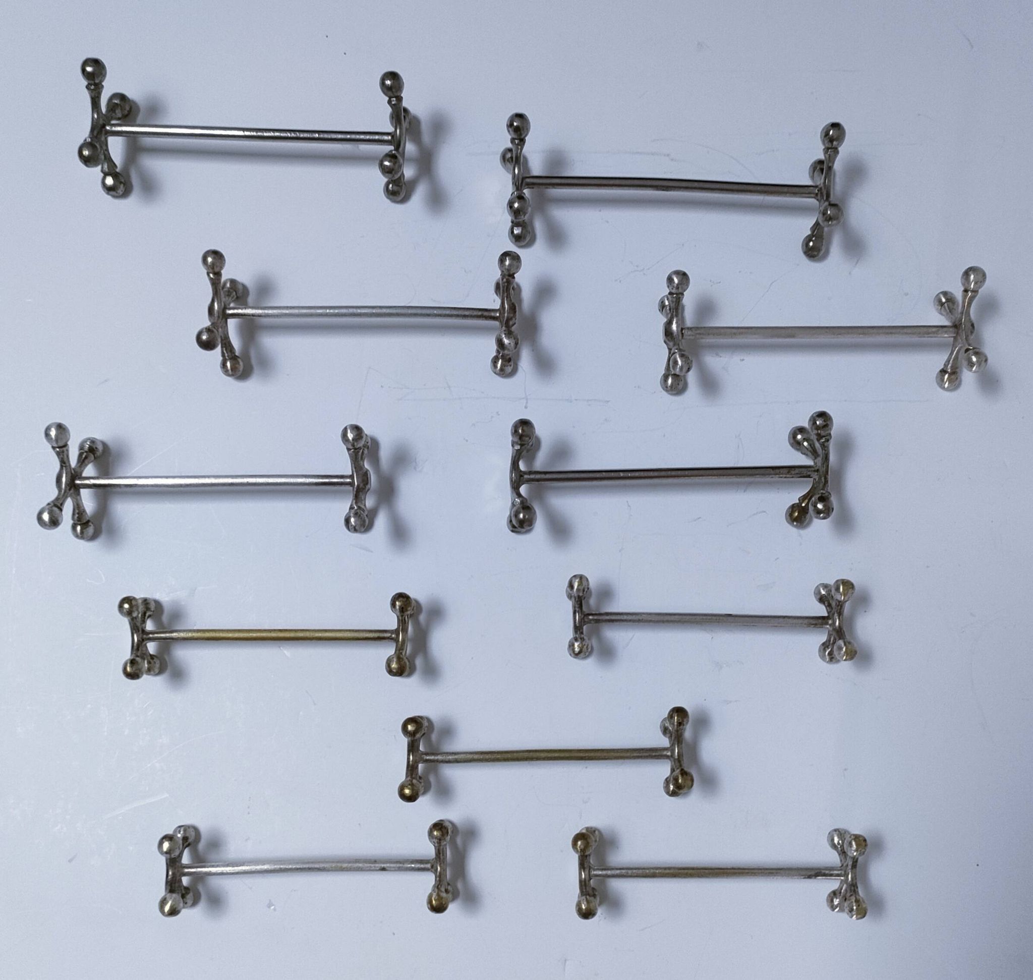 Eleven 70s design metal "crosshair" knife holders