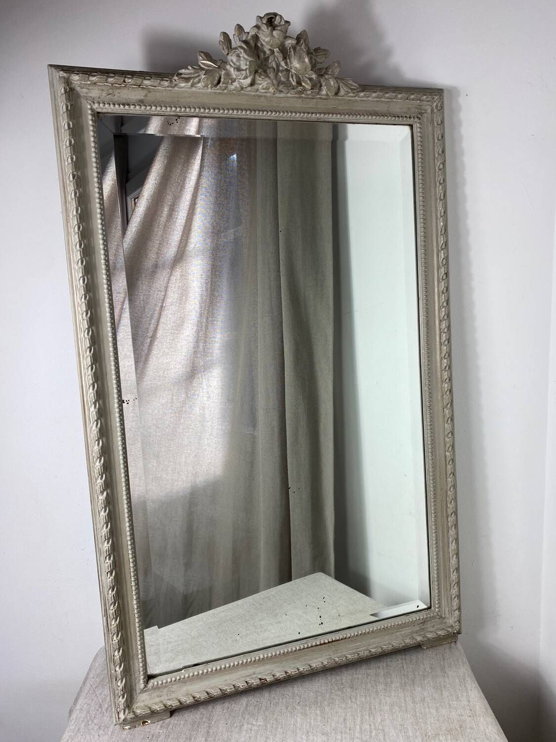 Large antique beveled mirror in carved wood painted with floral decoration and