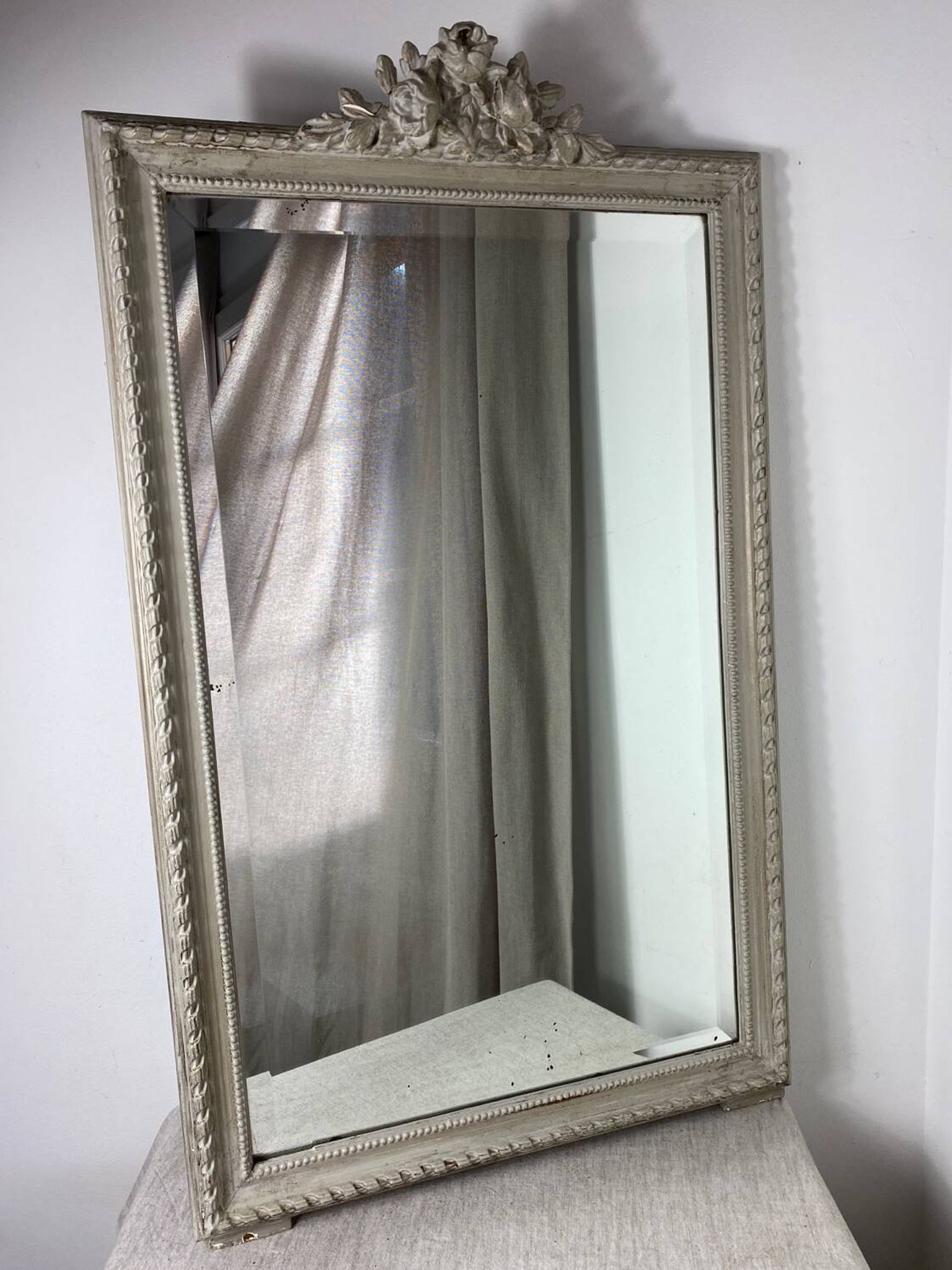 Large antique beveled mirror in carved wood painted with floral decoration and