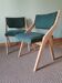 Scandinavian green chairs with tapered legs.