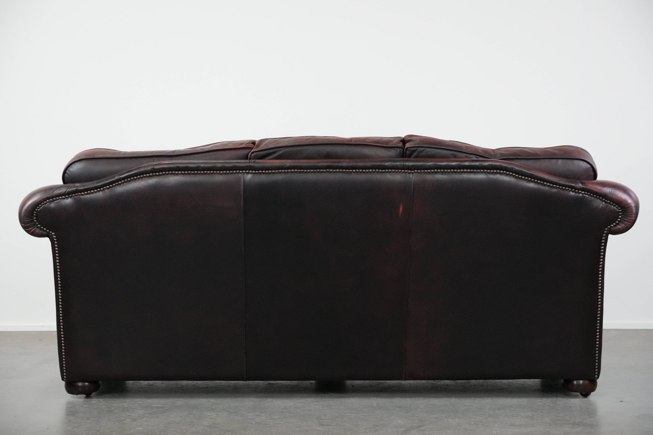 Red 2.5-seater Chesterfield sofa on wheels in English style