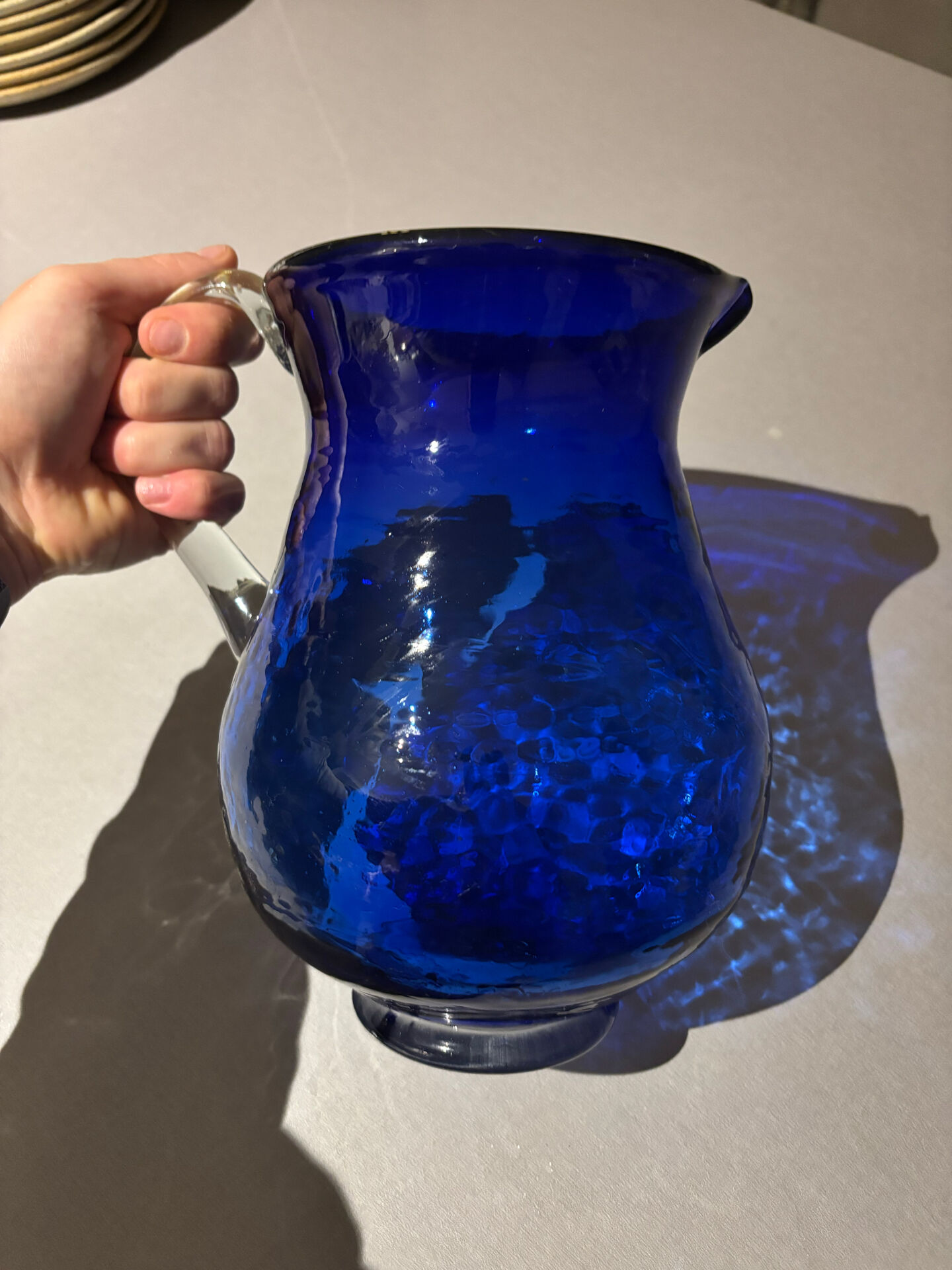 Vintage cobalt blue blown glass jug with a transparent handle.