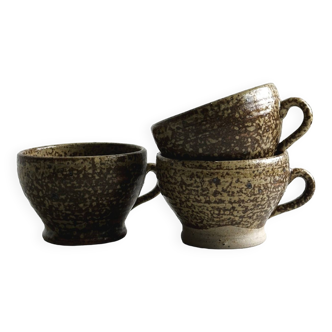 3 brown speckled ceramic cups, rustic and artisanal design.