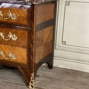 Louis XV style commode in rosewood and palisander veneer, gilt bronze mounts, and Rance marble top.