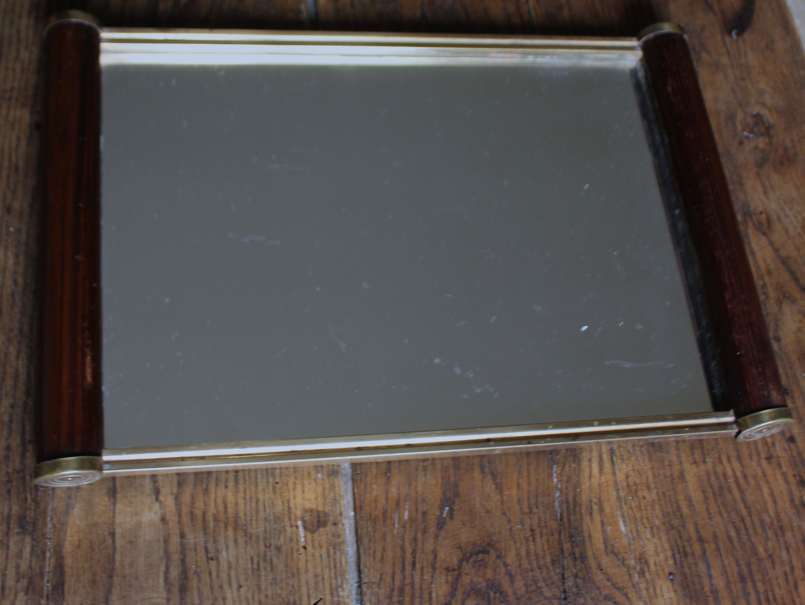 Rectangular mirror tray with wooden handles and gilding.