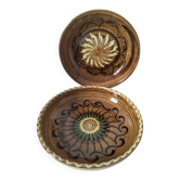 A pair of glazed earthenware deep plates with a solar design.