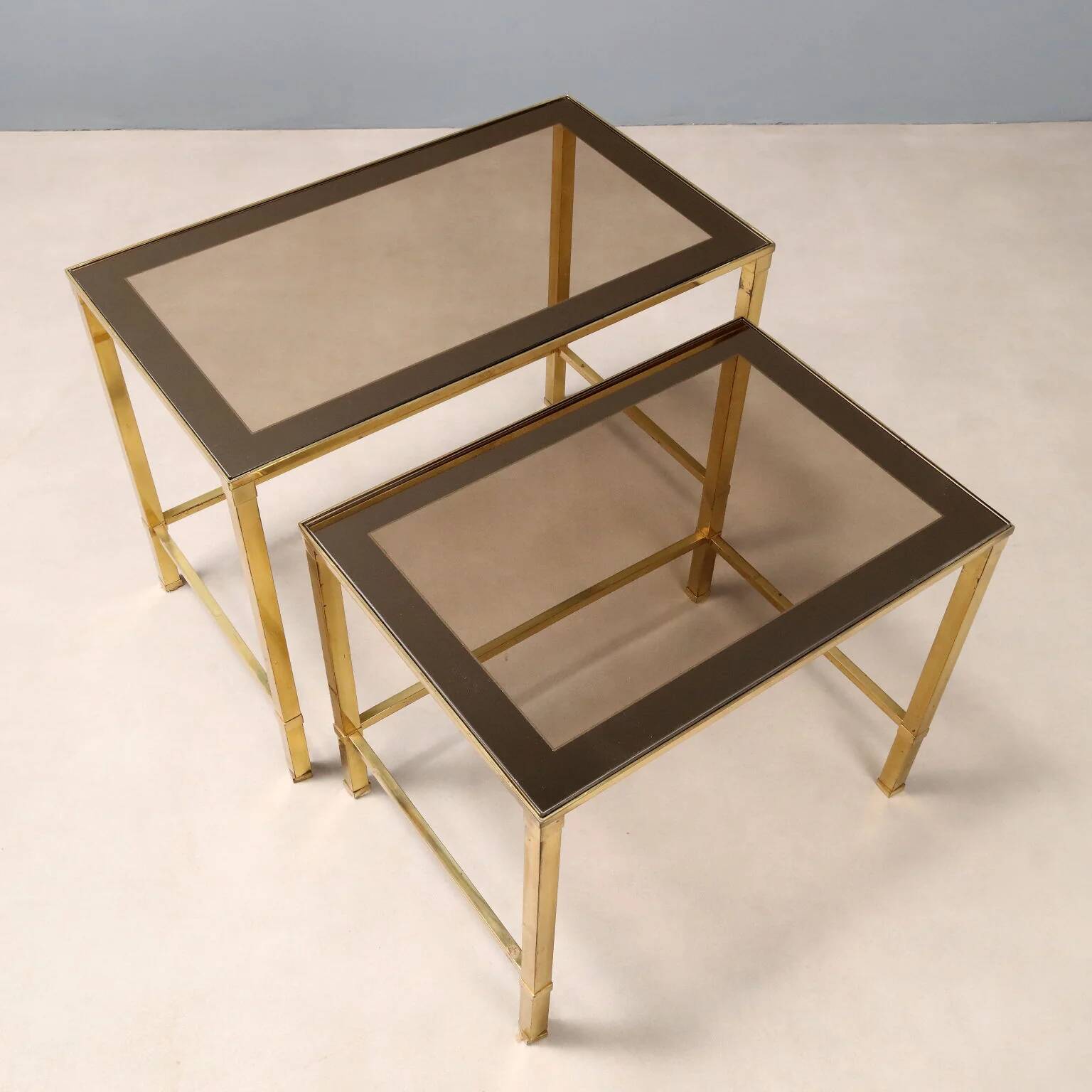 Nested tables in brass and smoked glass.