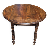 Round dining table with a drop-leaf top in solid walnut, late 19th century.