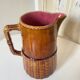 Antique vintage ceramic pitcher or jug from Sarreguemines, France. Brown with a pink interior, imitation basket.