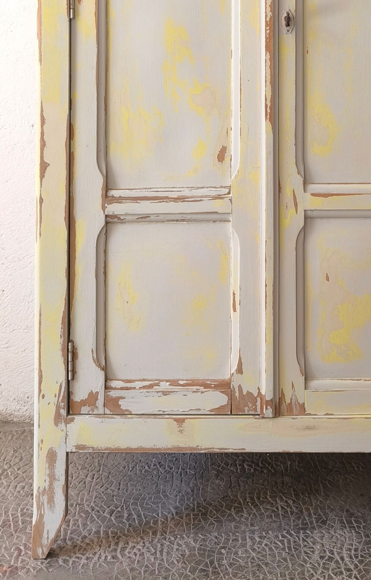 Small antique wardrobe patinated in beige and yellow.