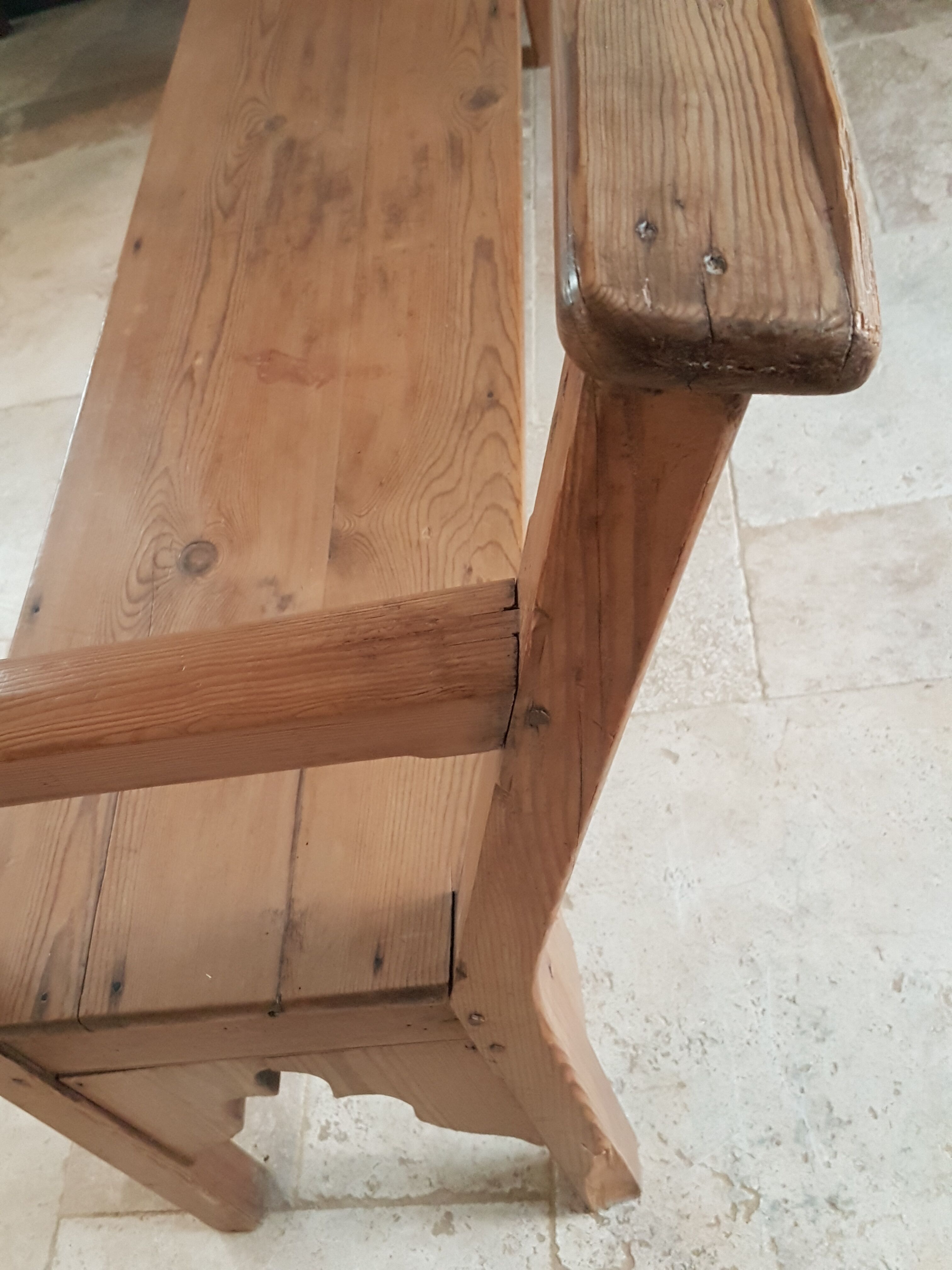 Church bench in fir tree with armrests