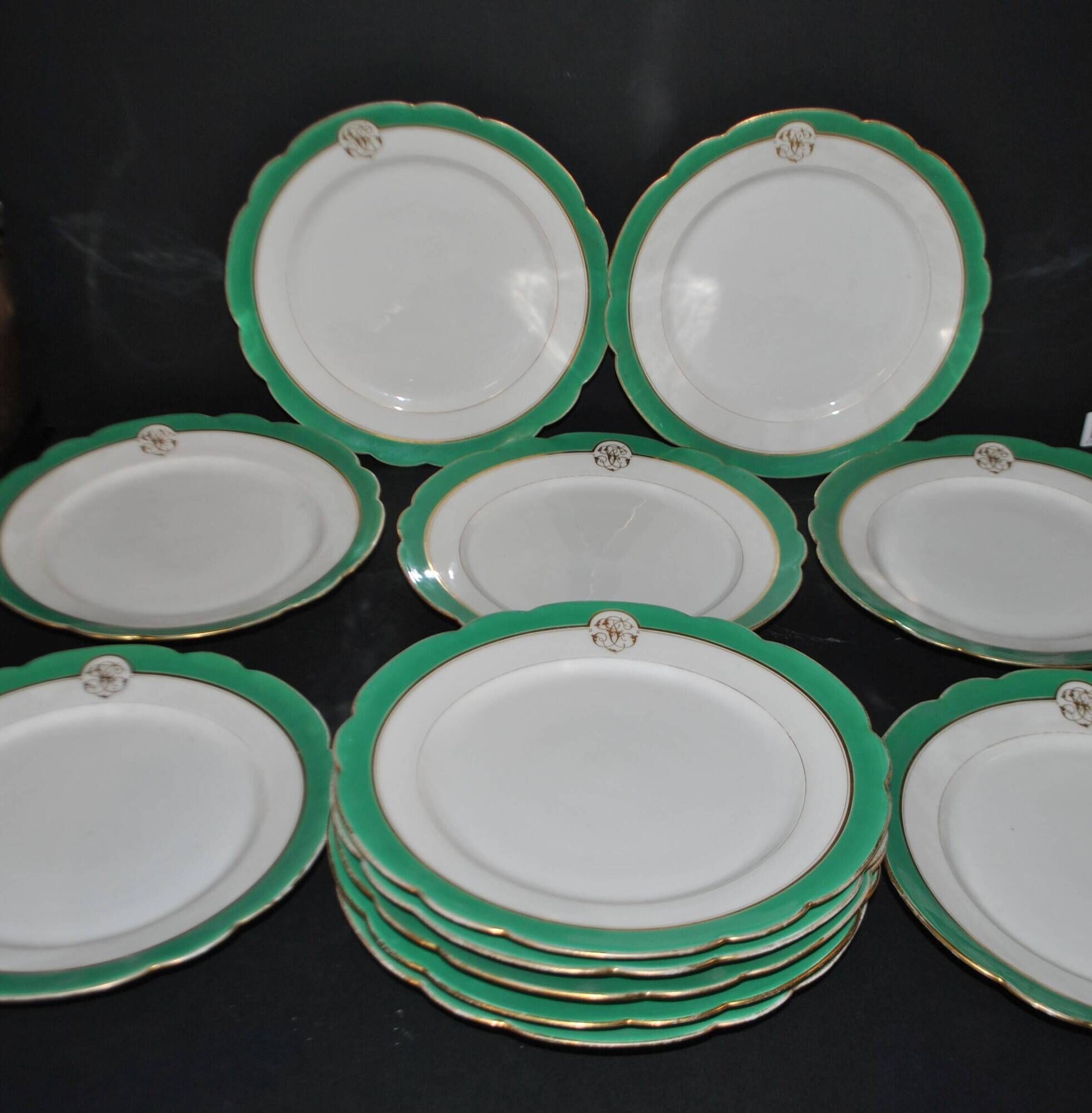 Paris porcelain set of 12 flat plates with green border and gold monogram JC.