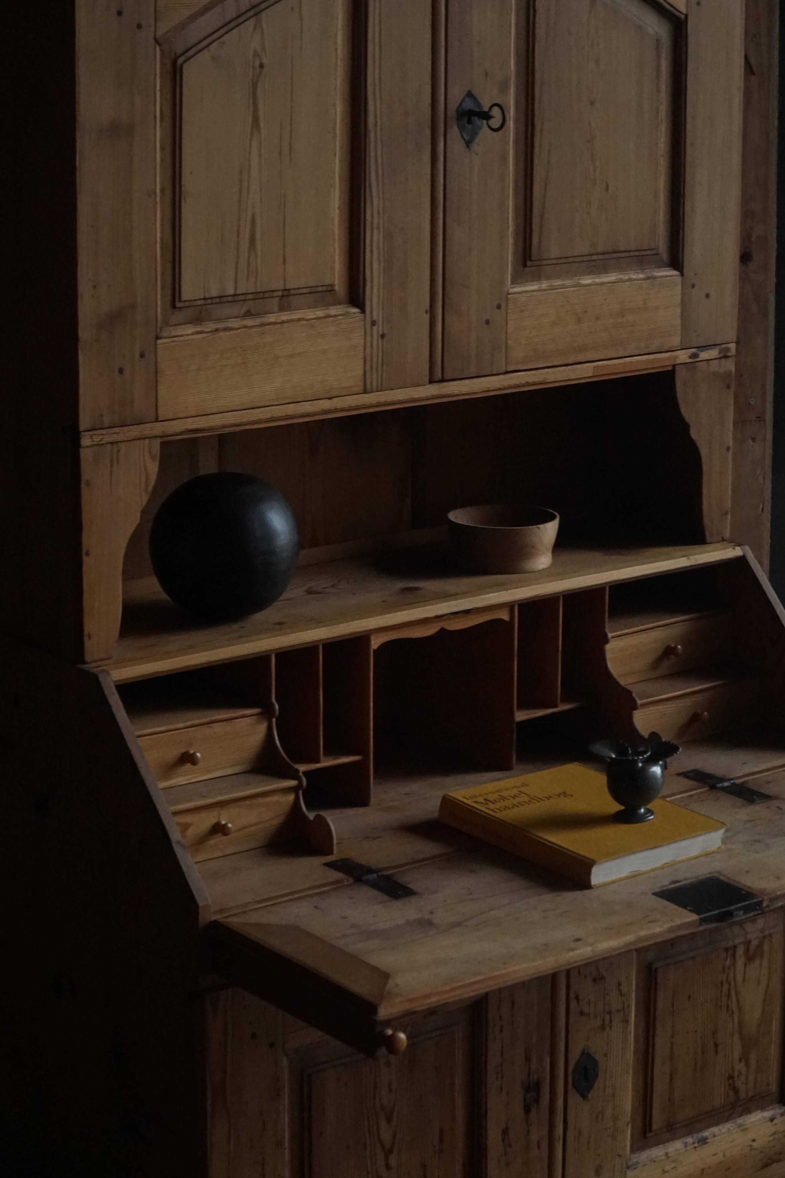 Old Danish secretary in pine with drop-down front and upper cabinet, mid-19th century.