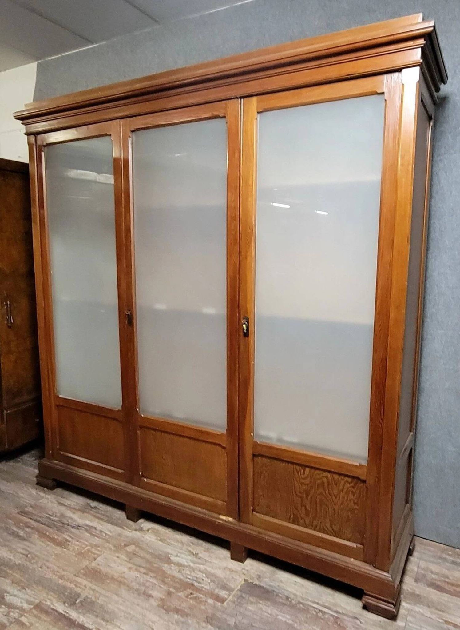 Large pine bookcase with three doors, fitted with frosted glass.