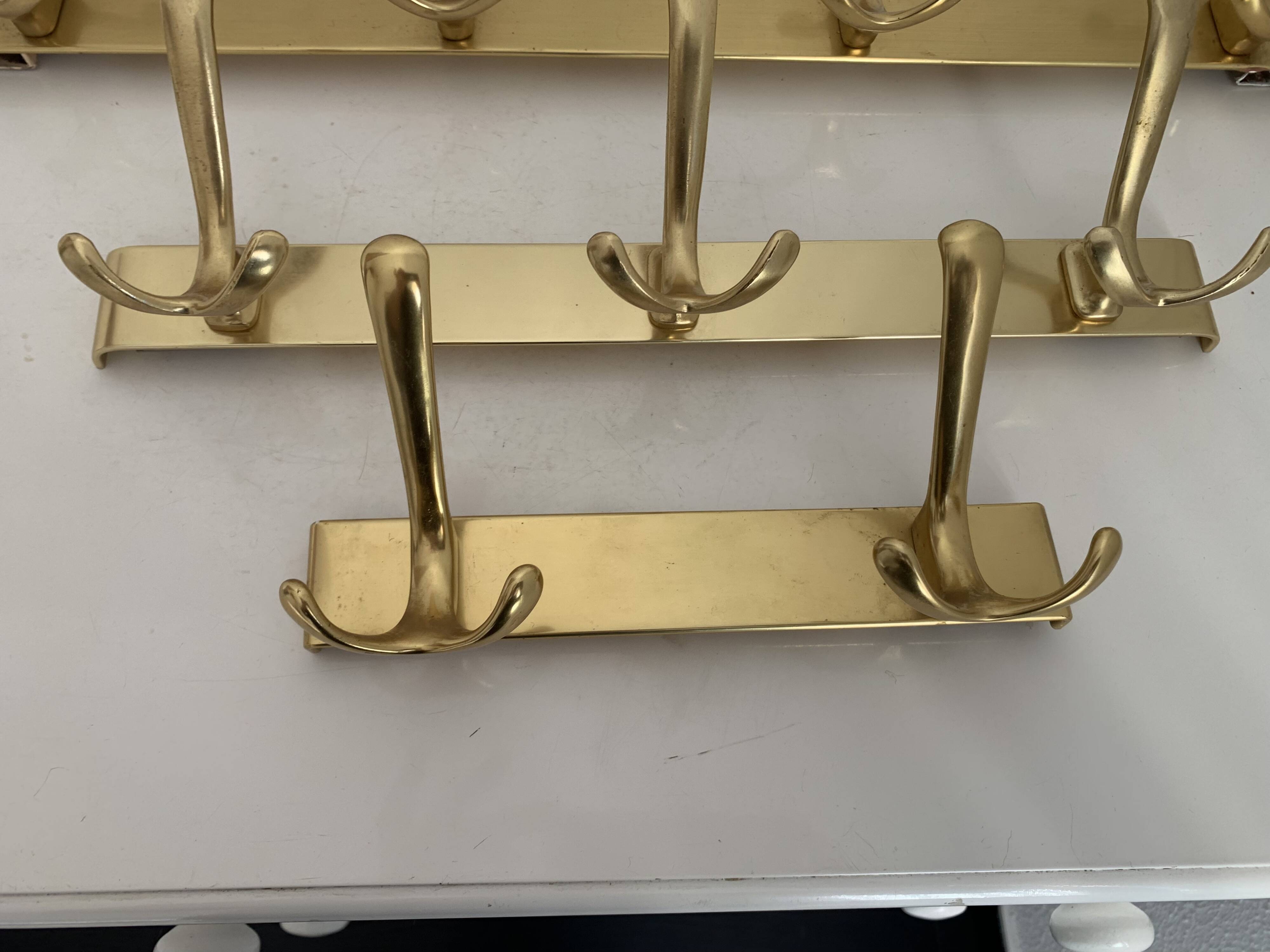 Three vintage 1960s gold coat racks with 4, 3 and 2 hooks