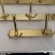 Three vintage 1960s gold coat racks with 4, 3 and 2 hooks