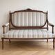 Louis XV style classic canapé reupholstered in striped beige fabric.