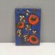Ceramic relief in attractive blue with a motif of white/red flowers.