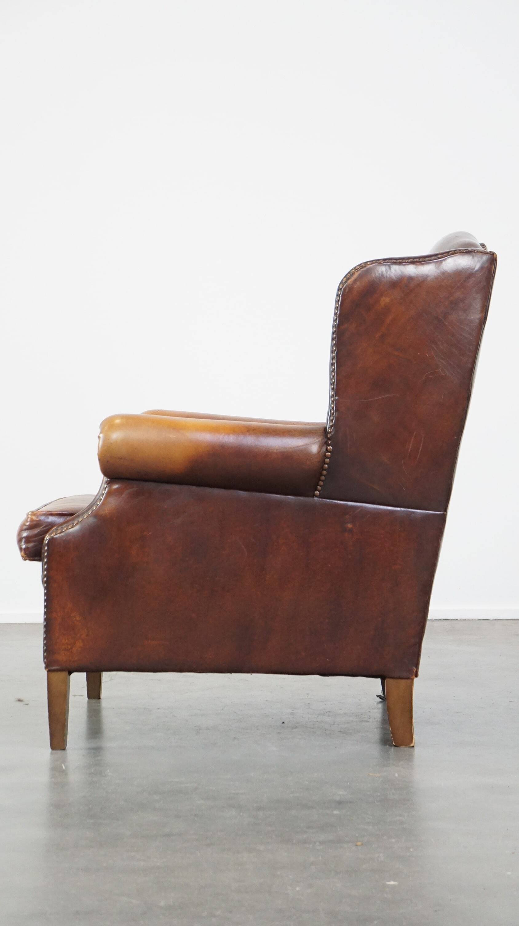 Comfortable, elegant, stately wing chair made of sheepskin in a beautiful warm color