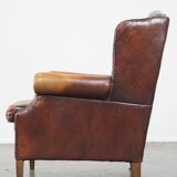 Comfortable, elegant, stately wing chair made of sheepskin in a beautiful warm color