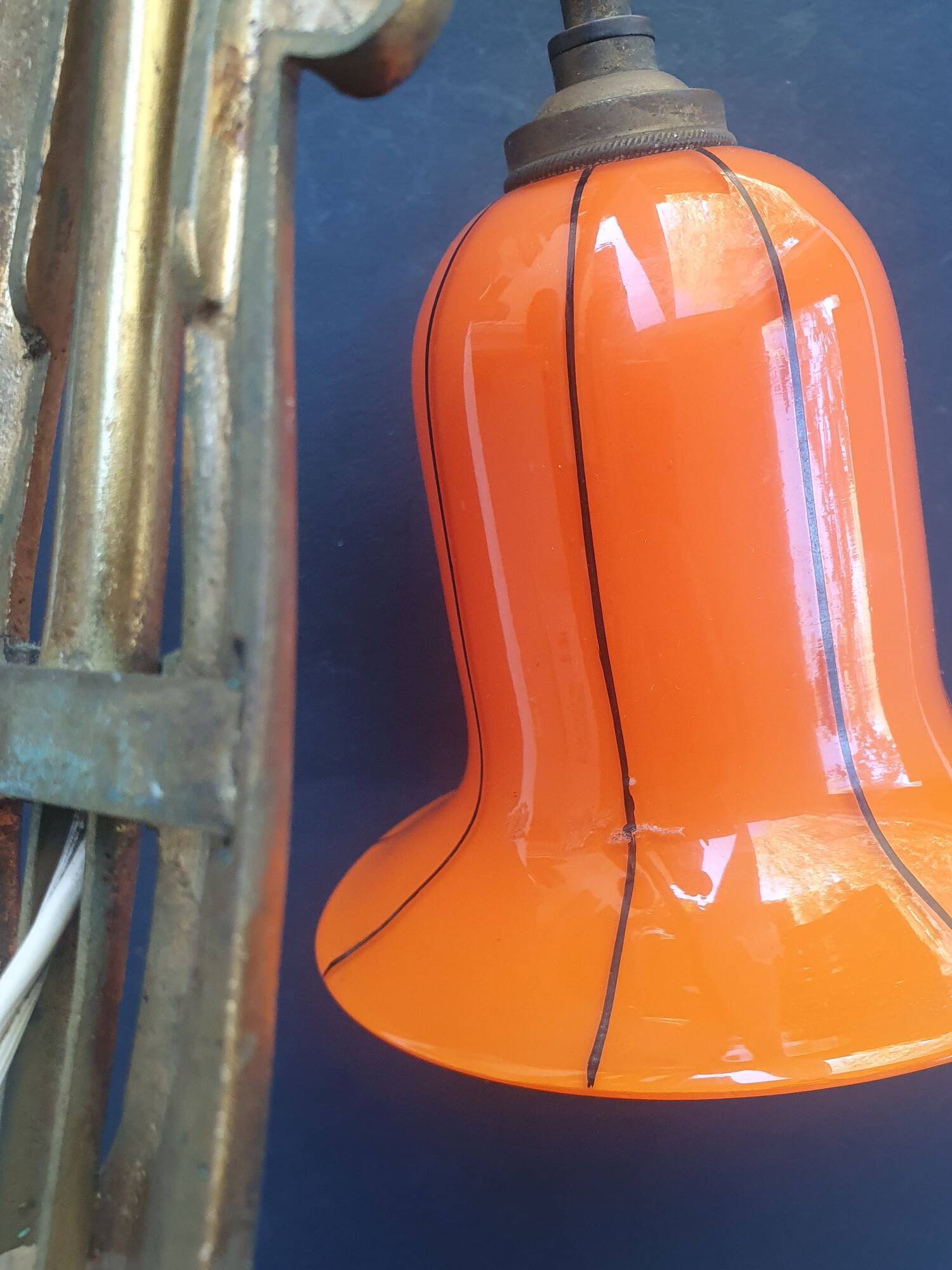 Art Deco wall light in brass with an orange globe.