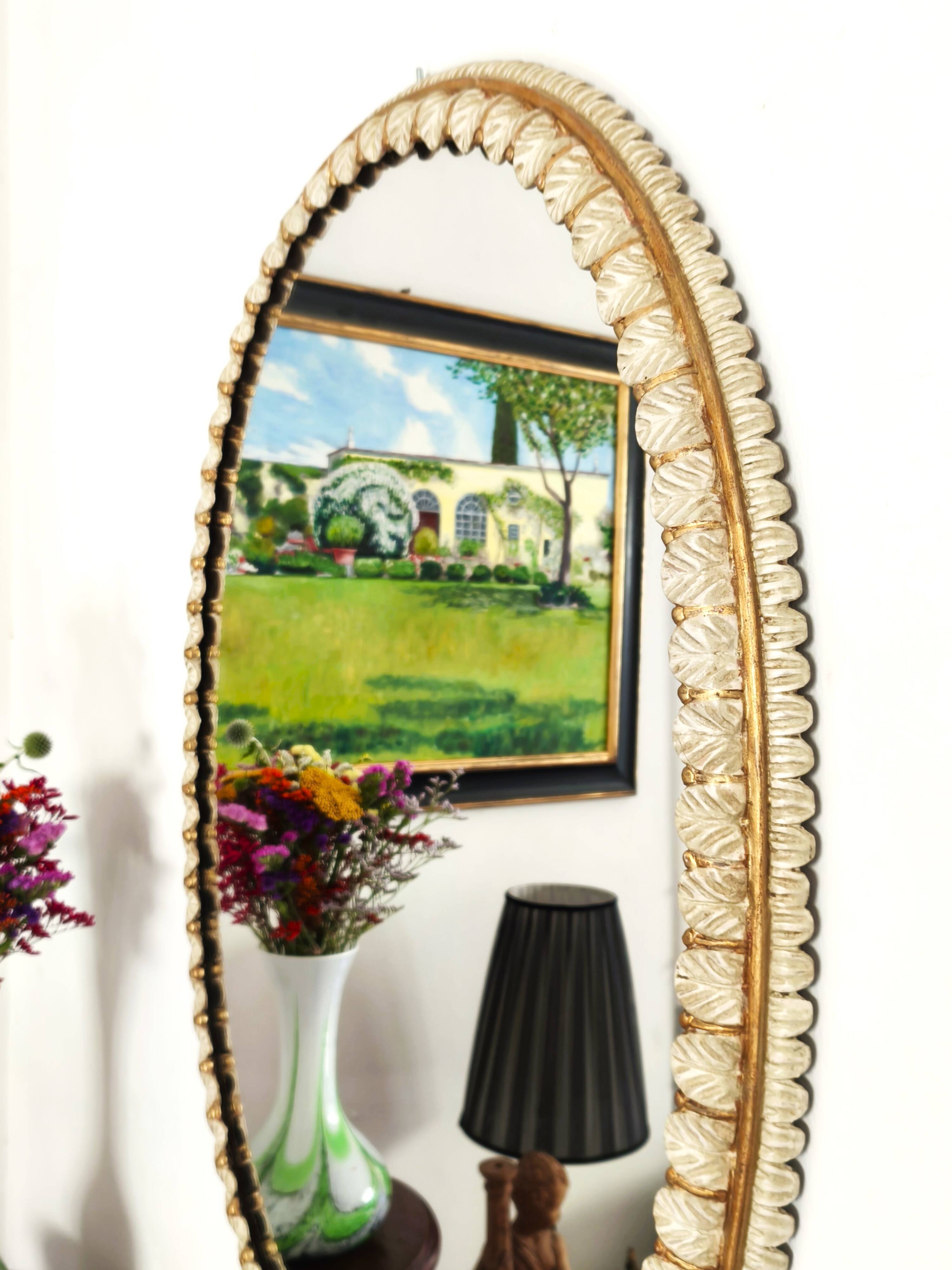 Large oval Florentine mirror in carved wood and gilded with gold leaf.