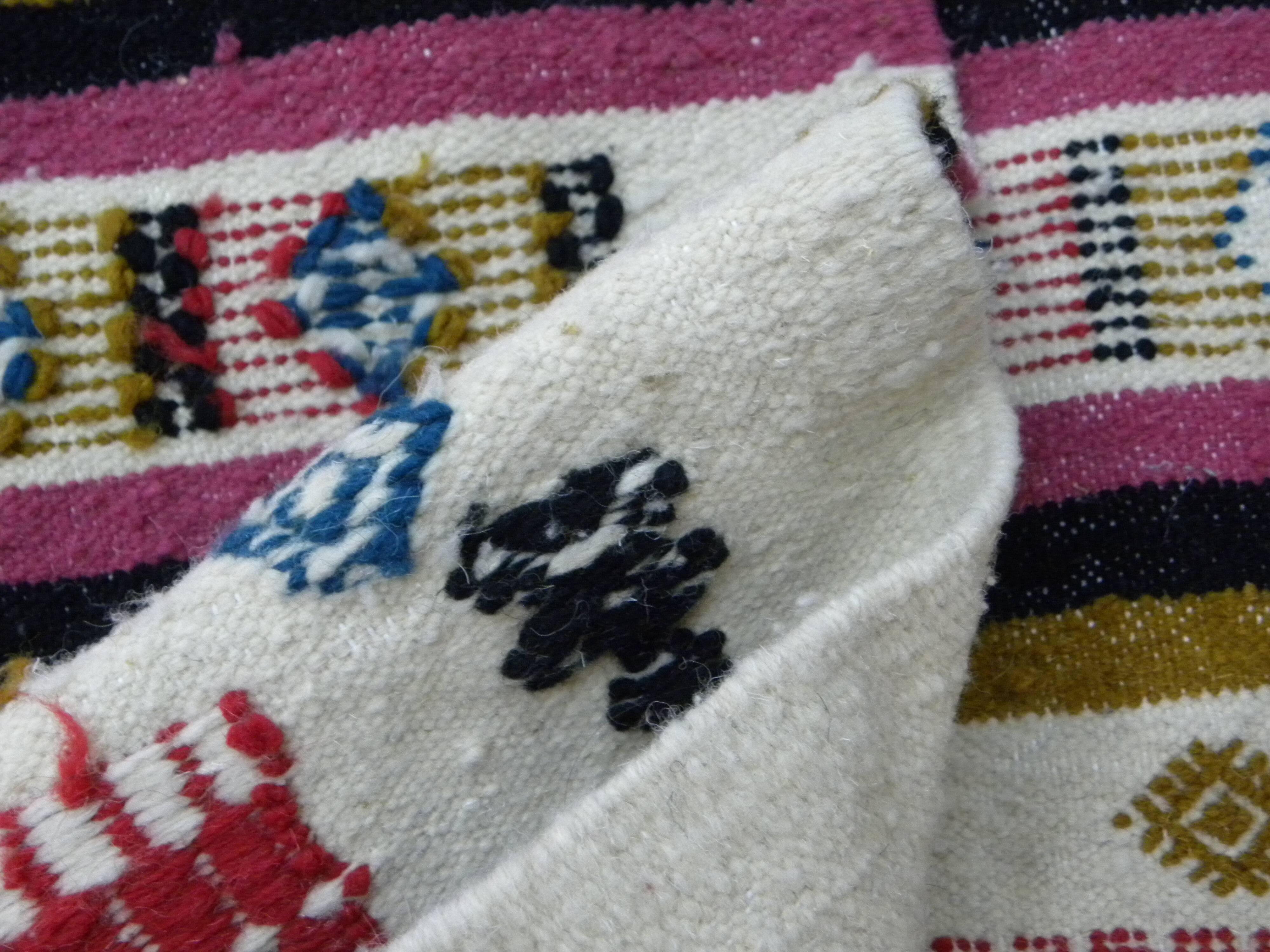 Handmade Berber kilim rug with multicoloured tribal motifs.
