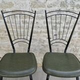 Black metal chairs with khaki faux leather seats, circa 1960.