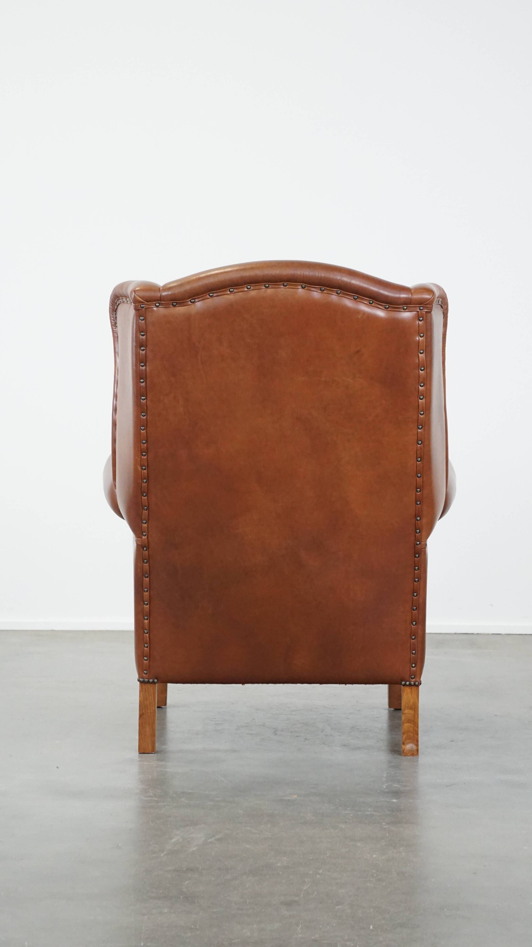 Cognac-colored leather wingback chair in English style