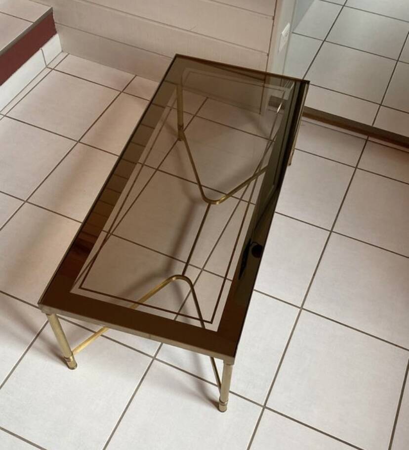 Rectangular neoclassical coffee table in gilded brass with a glass top.