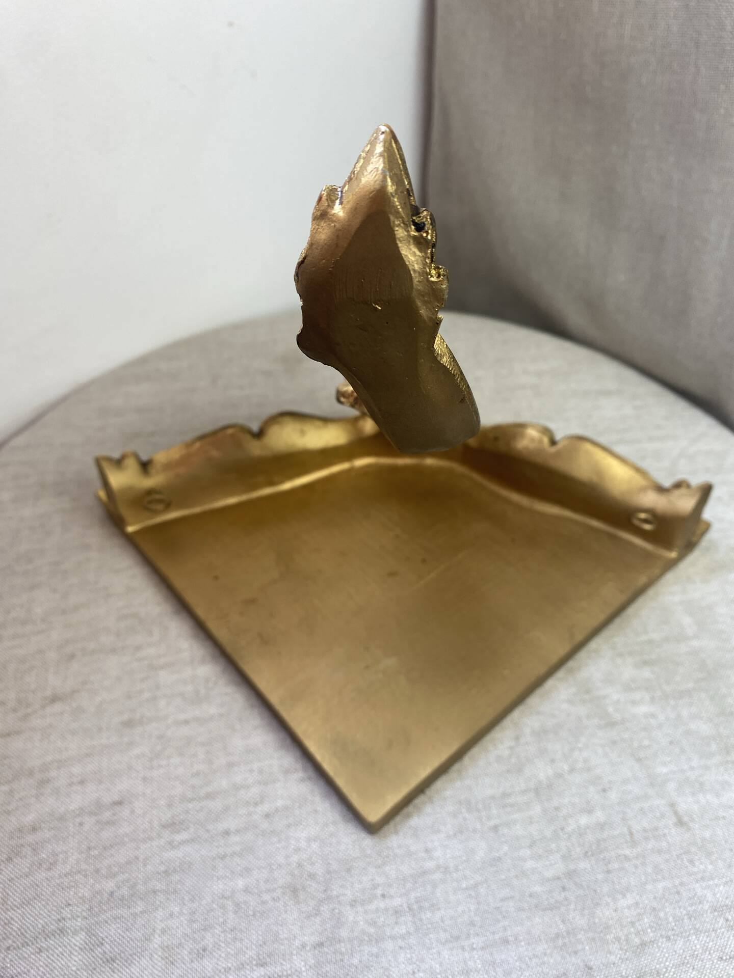 Small corner console in resin with a gold finish.