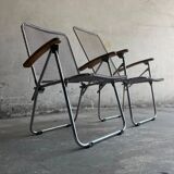 Pair of vintage silver aluminum wire folding chairs with wooden armrests — industrial minimalist