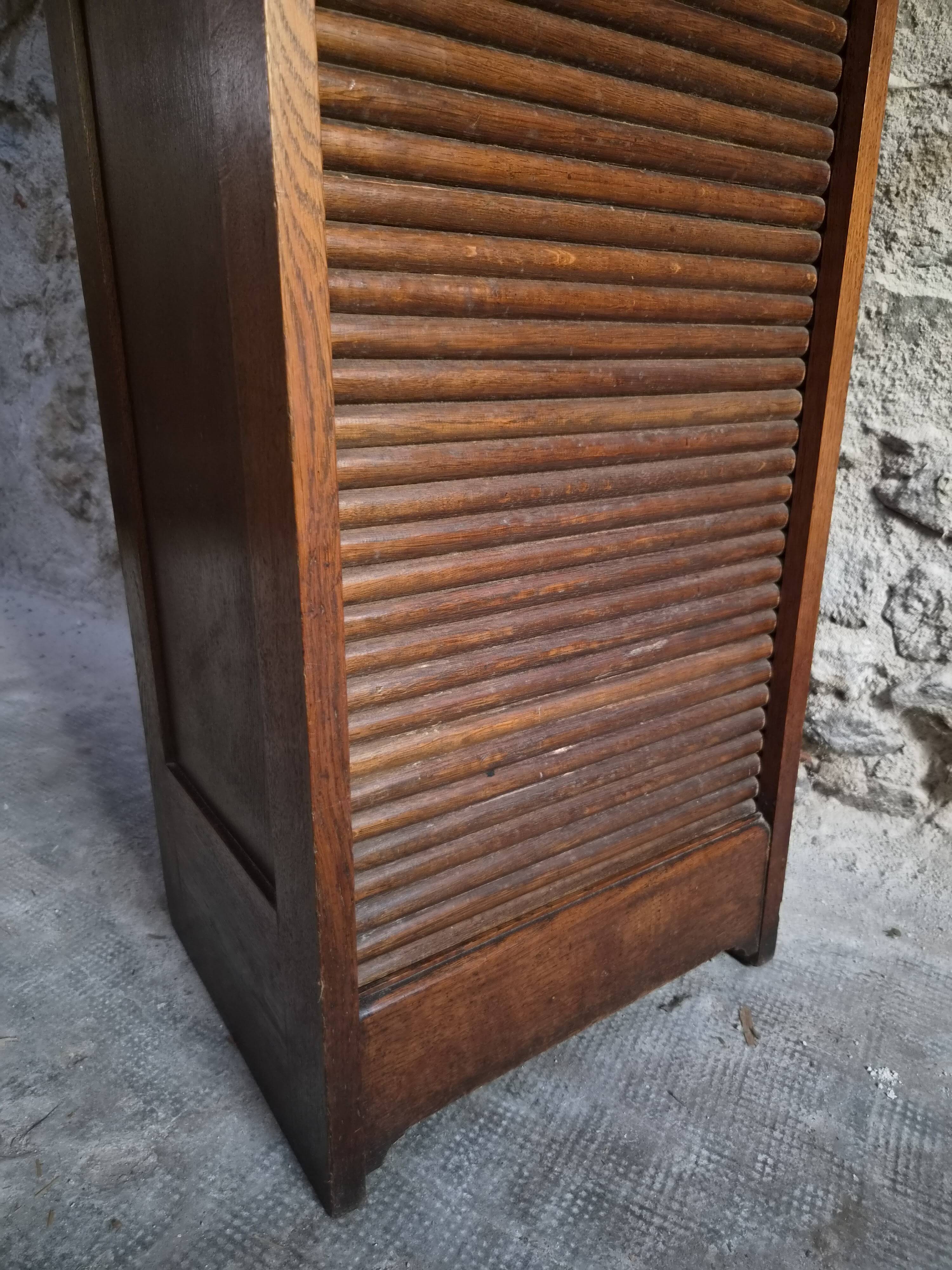 French antique wardrobe with curtain in oak, circa 1920–1930.