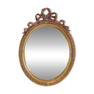 Wear consistent with age and use Wood and gilded plaster "Noeud d'Amour" Oval mirror