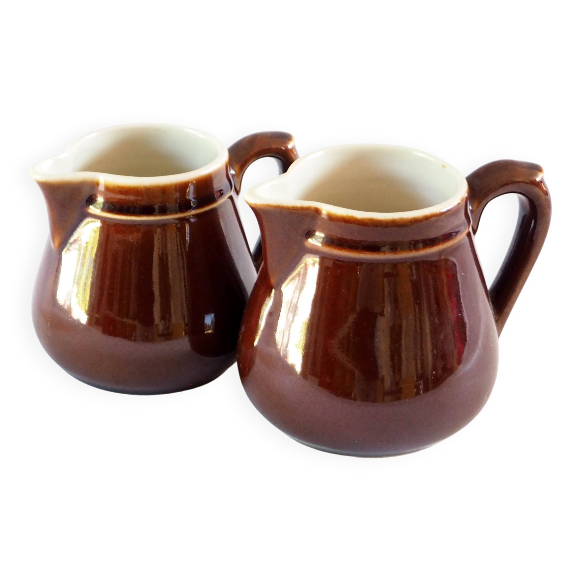 Duo of brown enamel pitchers