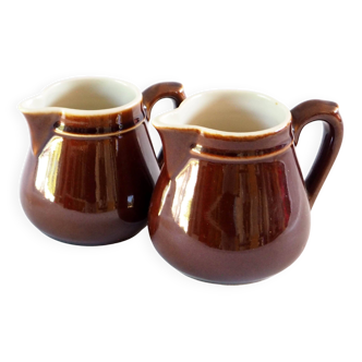 Duo of brown enamel pitchers