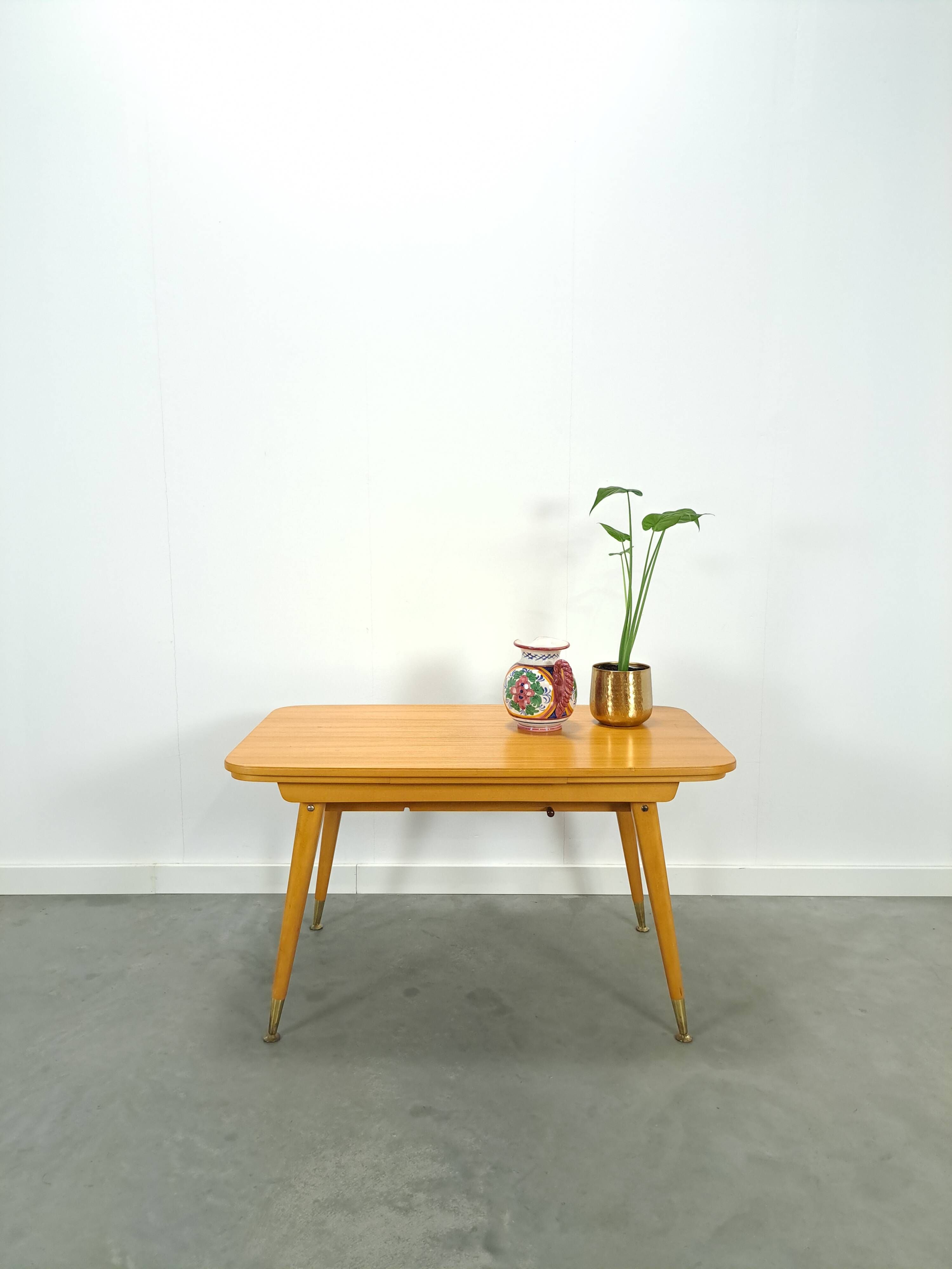 Vintage veneer table with pretty angular legs and brass at the base of the legs.
