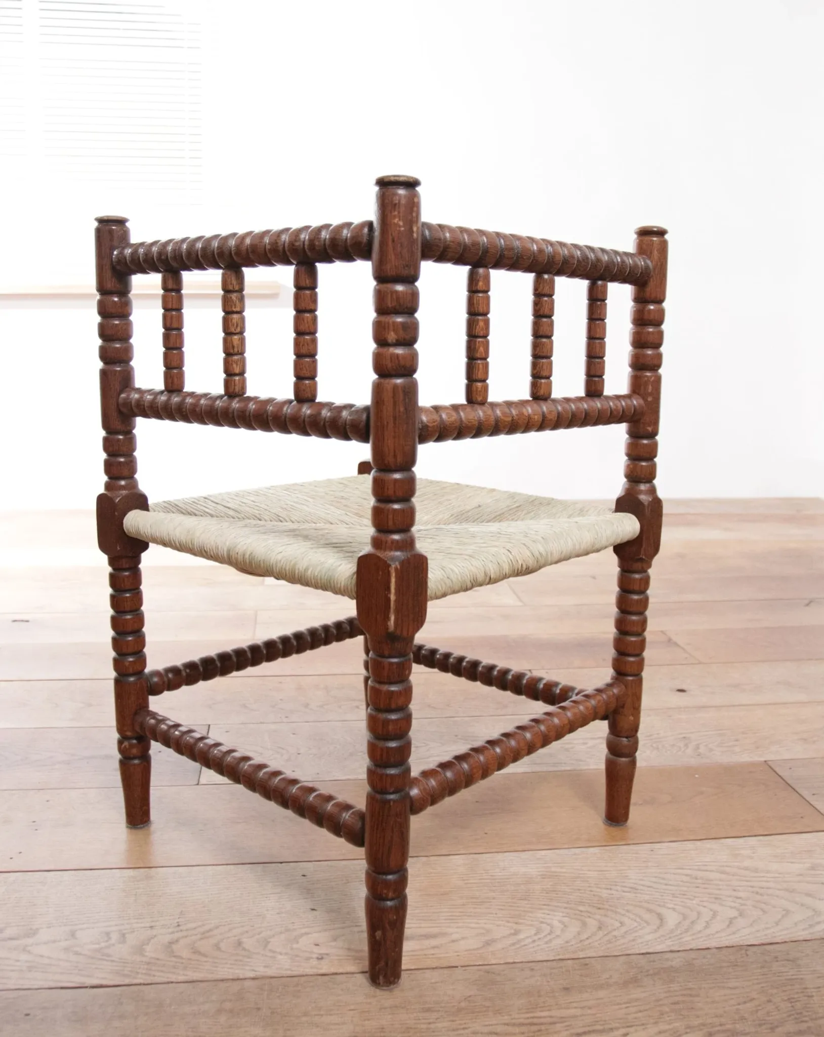 Antique Dutch oak corner chair with turned spindles and new rush seat