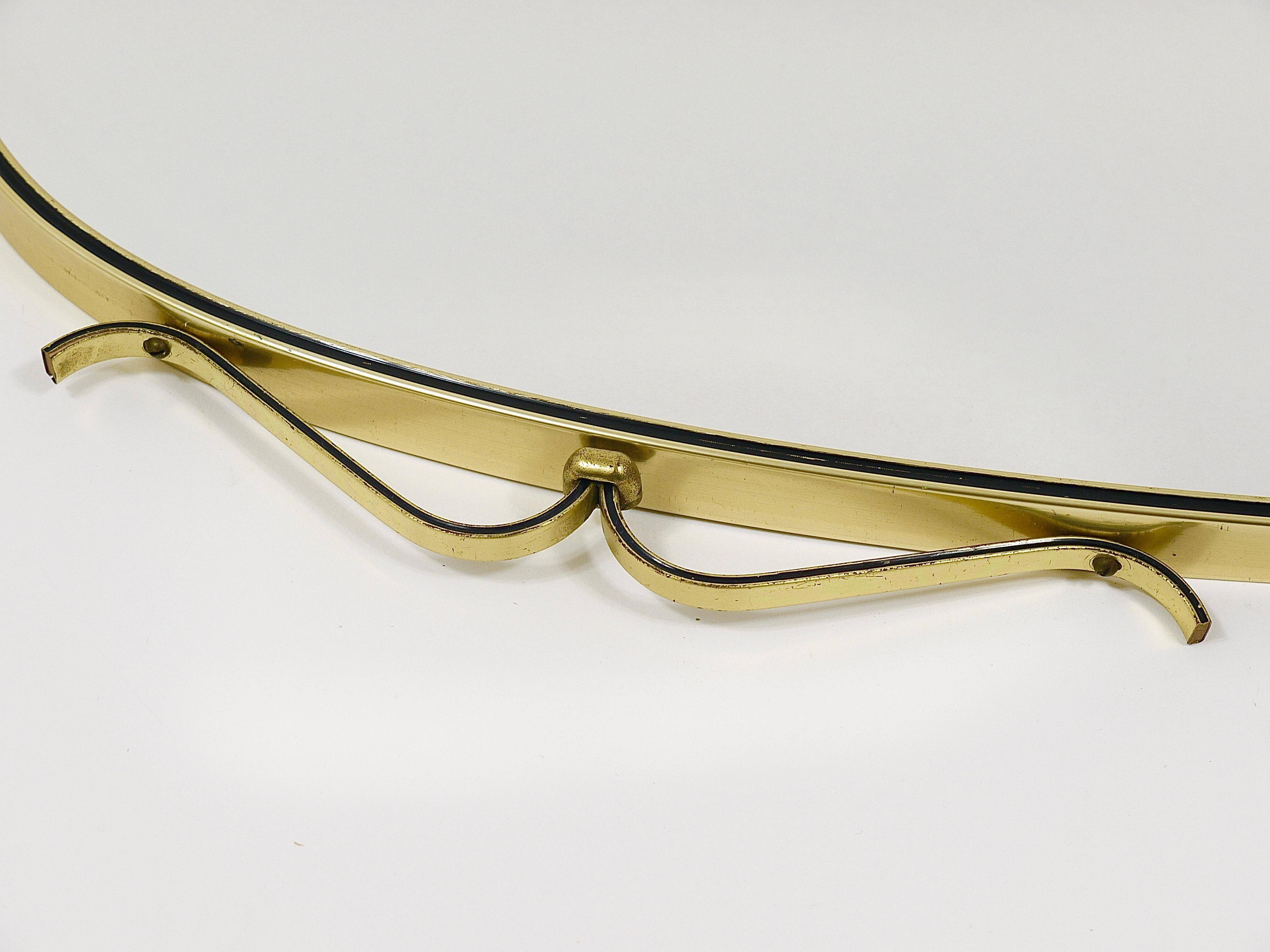 Elegant wall mirror in brass and black from the mid-century, Italy, 1950s.