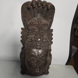 Ancient Indian carved wooden mask sculpture of a deity with a cobra.