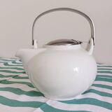 White porcelain teapot. Shiny stainless steel handle and lid