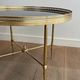 Round coffee table in brass with a black lacquered glass top from Maison Jansen.