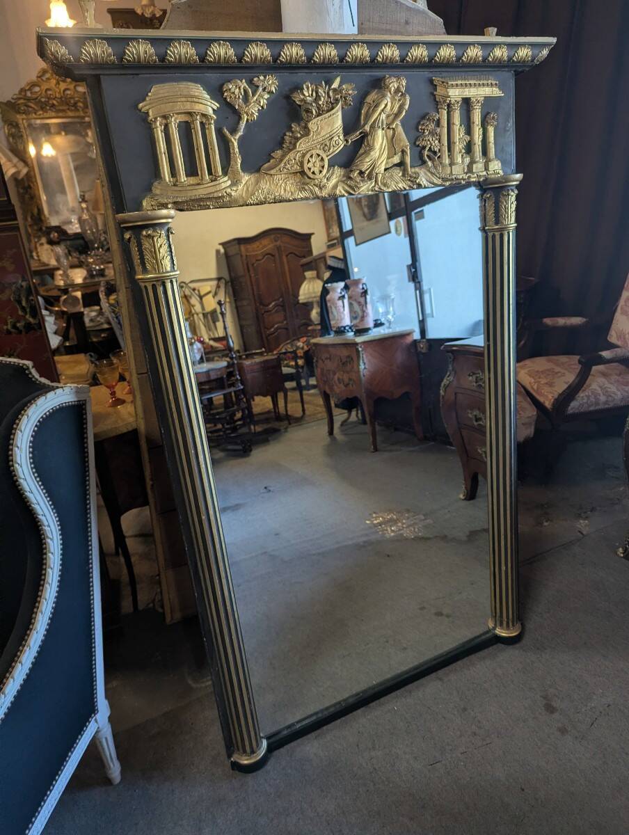 Large Empire-style mirror in dark green painted wood and gilded stucco.