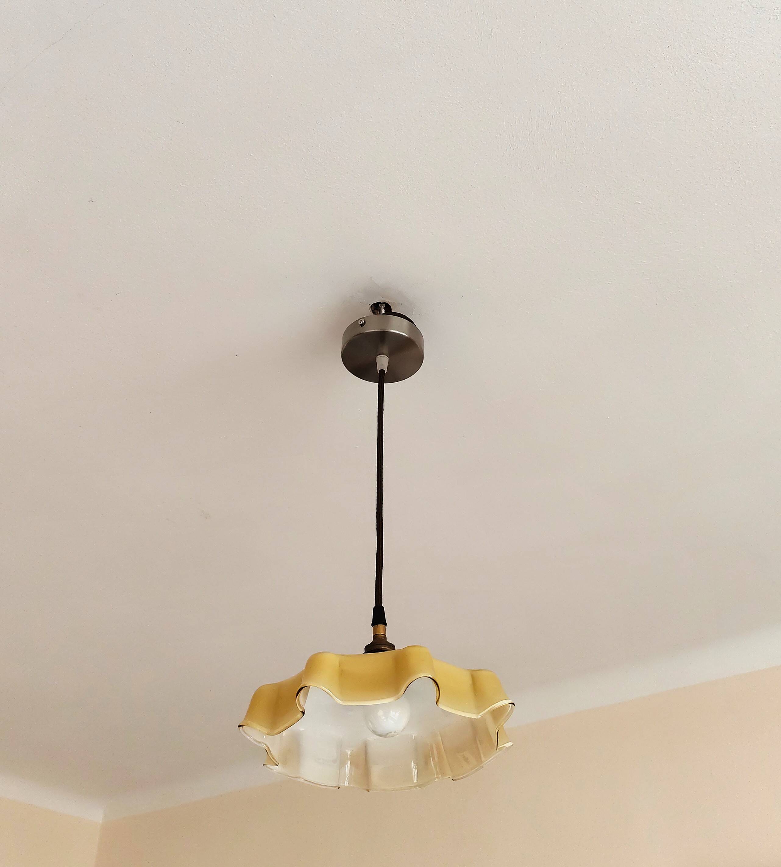 Electrified suspension with a frosted opaque glass disc shade.