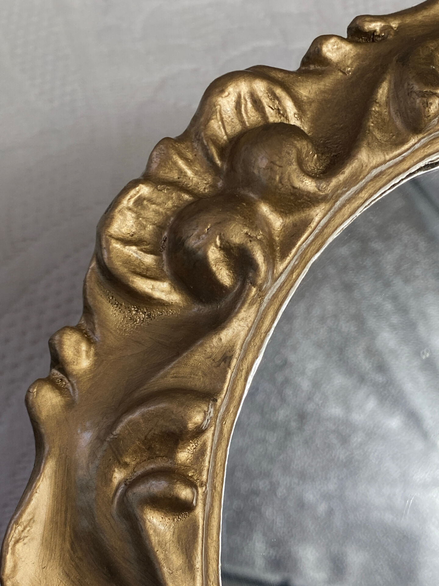 Round wooden mirror in golden colour.