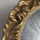 Round wooden mirror in golden colour.
