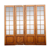 Suite de quatre portes de séparation en bois patiné carreaux biseautés XX siècle