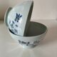 Two vintage farm bowls on a pale blue pedestal with floral decoration.