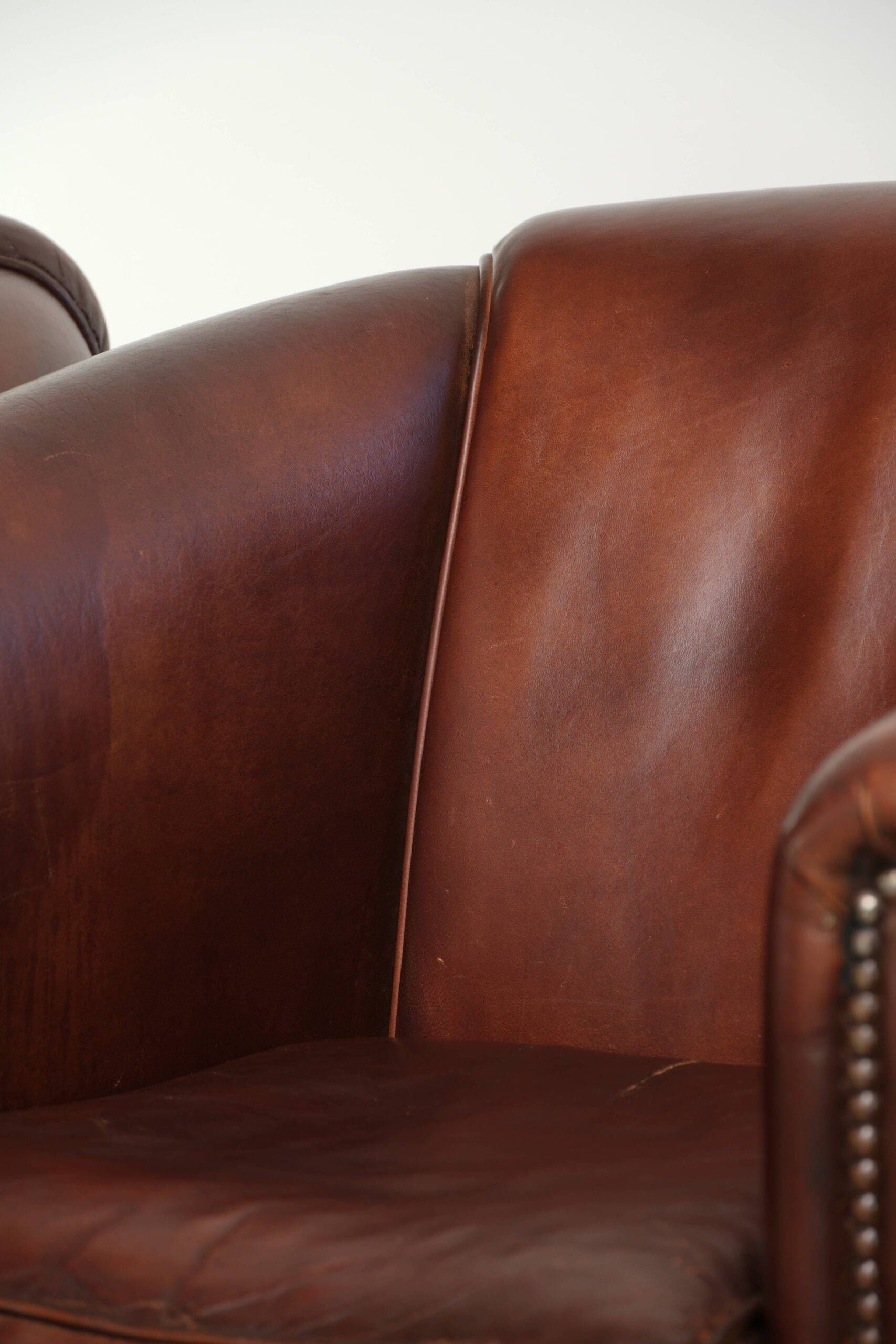 Set of 2 sheepskin club armchairs in a dark cognac colour